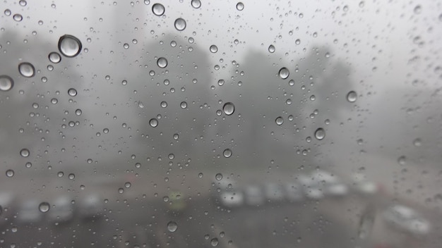 Close-up van een nat glasvenster tijdens het regenseizoen