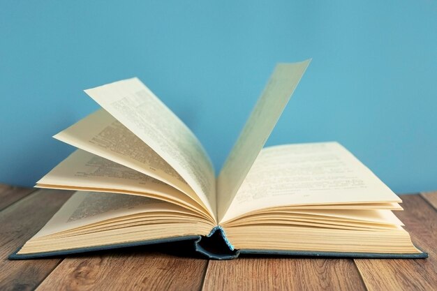 Foto close-up van een open boek op tafel tegen een blauwe achtergrond