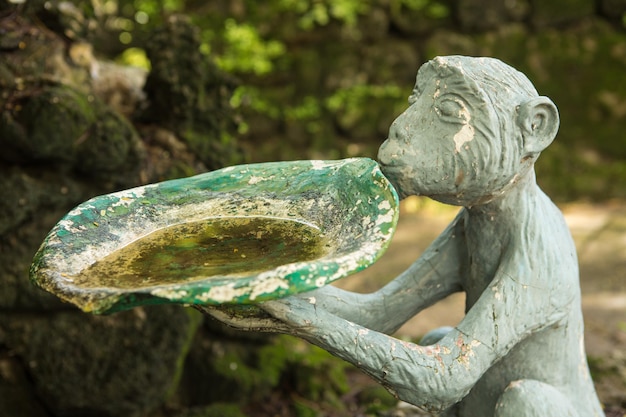 Foto close-up van een oud standbeeld tegen planten