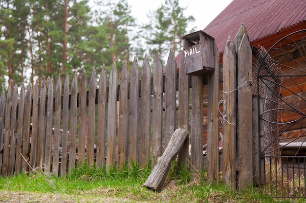 Close-up van een oude houten hek met een vogelhuisje in het dorp van een zomerse dag