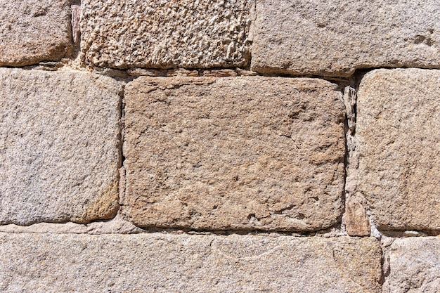 Close-up van een oude muur van grote stenen bakstenen die een uitstekende decoratieve achtergrond vormen