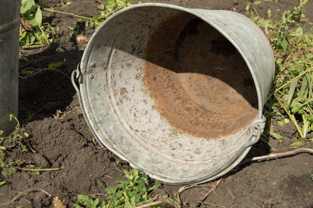 Close-up van een oude vuile roestige ijzeremmer die op de grond ligt