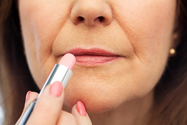 Close-up van een oudere vrouw die lippenstift aanbrengt