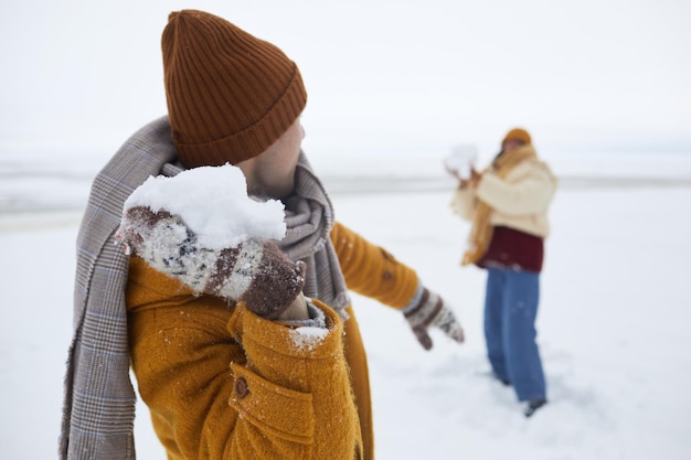 Close-up van een paar dat sneeuwballengevecht buiten speelt in de winter kopieerruimte