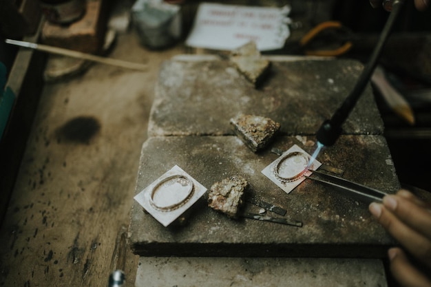 Foto close-up van een persoon die aan een metalen rooster werkt