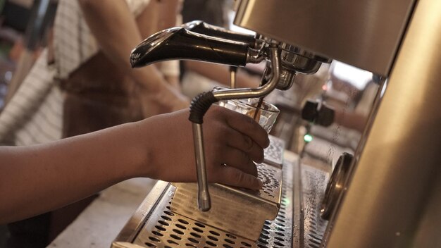 Foto close-up van een persoon die een koffiemachine gebruikt