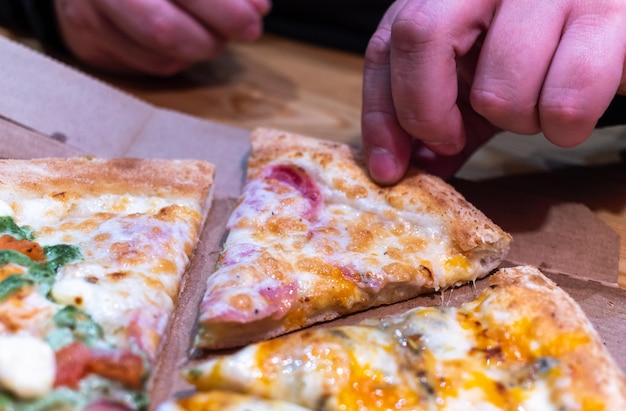 Foto close-up van een persoon die een pizza snijdt