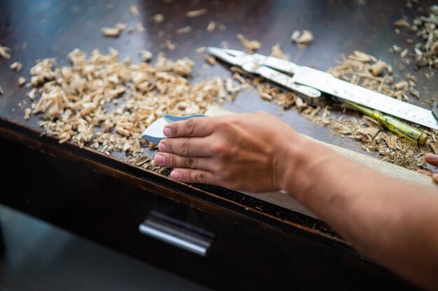 Foto close-up van een persoon die hout bewerkt in een werkplaats