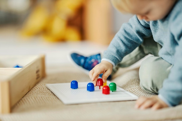 Close-up van een peuter die speelt met educatief spel en leerkleuren