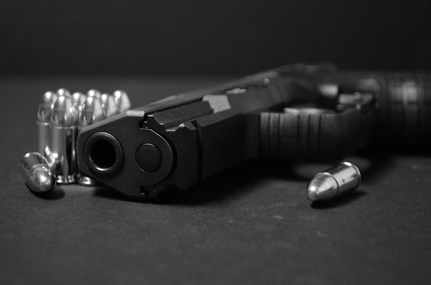 Foto close-up van een pistool met kogels op tafel