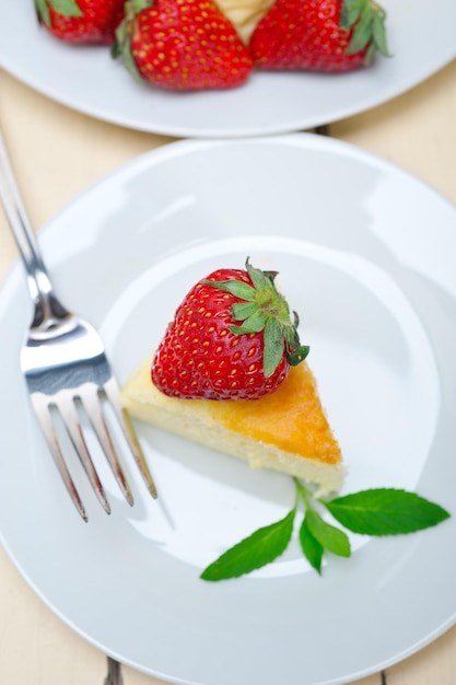 Close-up van een plak cheesecake met aardbeien op het bord