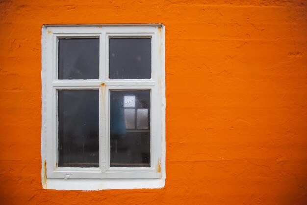 Foto close-up van een raam op een oranje muur