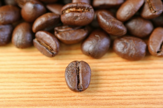 Close-up van een Robusta geroosterde koffieboon met wazige koffiebonen op de achtergrond