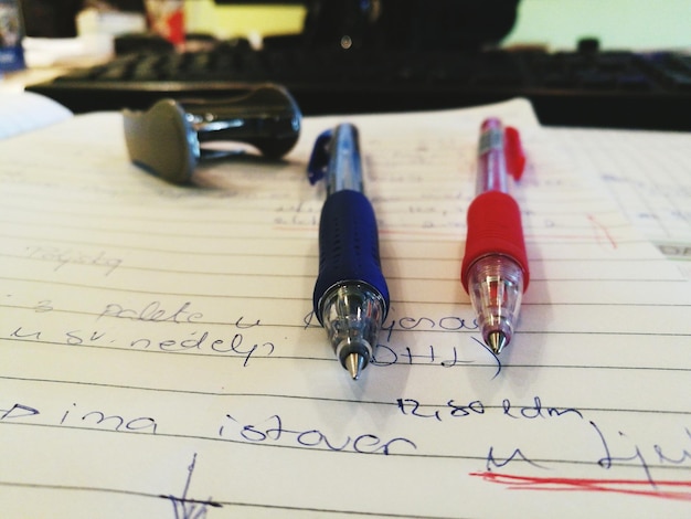 Foto close-up van een rode en blauwe pen op papier