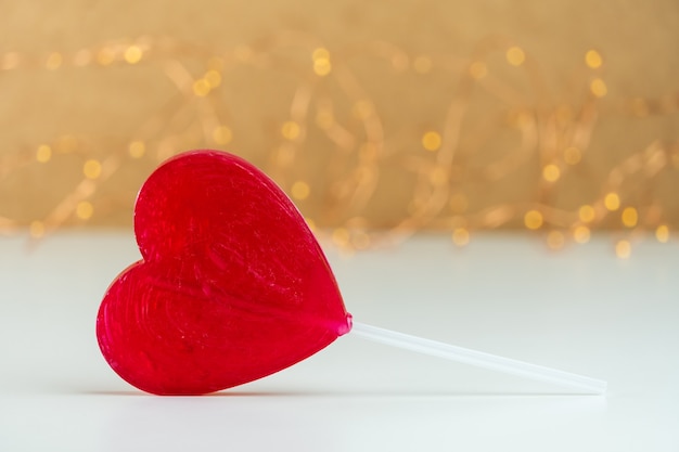 Foto close-up van een rode hartvormige lolly met onscherpe achtergrond