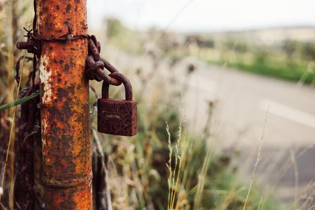 Foto close-up van een roestige hangslot bevestigd aan een paal