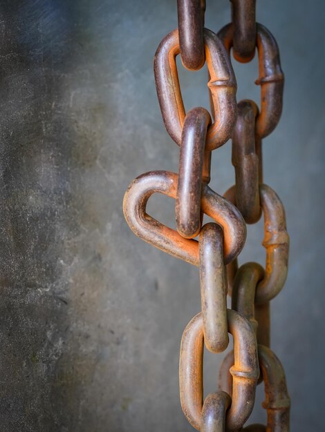 Foto close-up van een roestige ketting tegen de muur