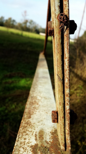 Foto close-up van een roestige metalen hek op het veld