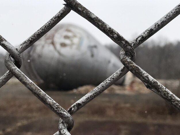 Foto close-up van een roestige metalen hek tegen de lucht