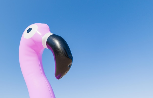 Close-up van een roze flamingo opblaasbaar hoofd tegen een heldere blauwe lucht