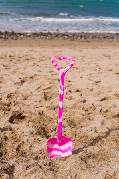 Foto close-up van een roze paraplu op het strand tegen de lucht