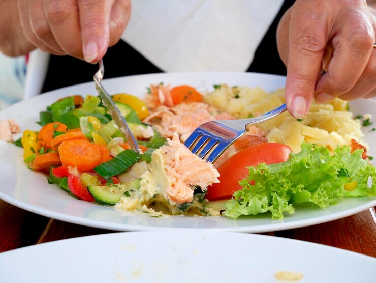 Foto close-up van een salade die met de hand op tafel wordt geserveerd