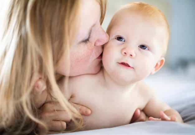 Close-up van een schattig baby meisje dat thuis op bed ligt.