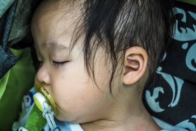 Foto close-up van een schattig meisje met een fopspeen dat op bed slaapt