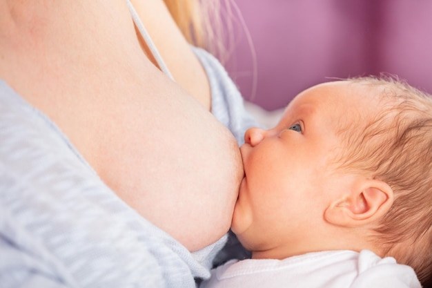 Close-up van een schattige baby die thuis op bed ligt.