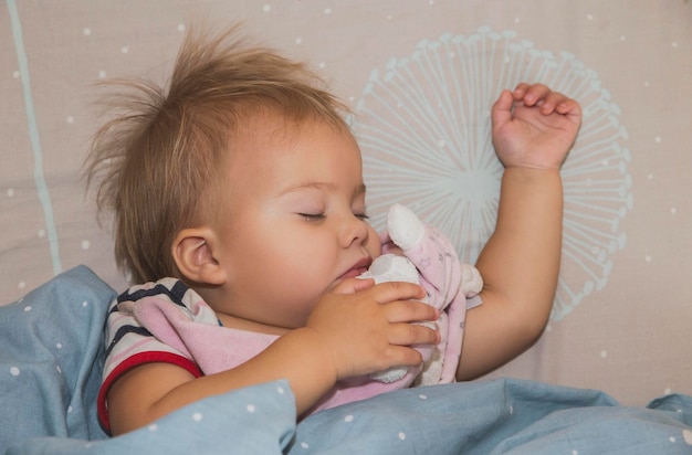 Close-up van een schattige baby die thuis op bed slaapt.