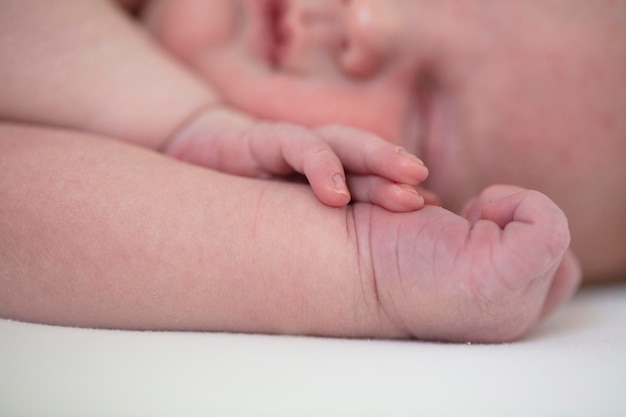 Close-up van een schattige slapende baby die op hun armen rust