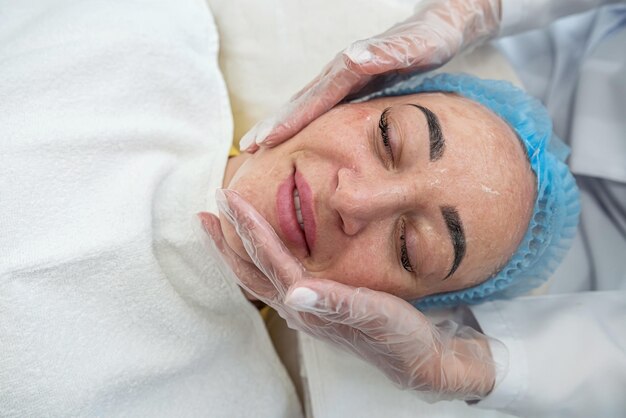 Close-up van een schoonheidsspecialiste die verjongende procedures uitvoert voor het gezicht van een klant in een spa of salon