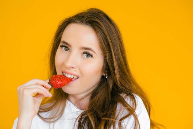 Close-up van een sexy vrouw die verse aardbeien eet Seksuele lippen rode lippenstift Gezonde voeding concept