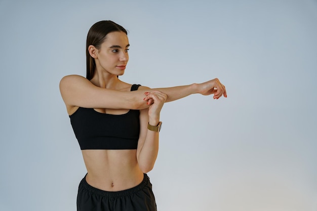 Close-up van een sportieve vrouw die zich opwarmt voor de training in de sportschool op de achtergrond van de studio
