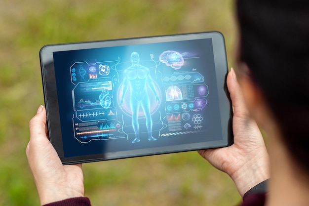 Close-up van een tablet in handen die de afbeeldingen van een medische technologiehologram afschilderen. geneeskunde van de moderne tijd.