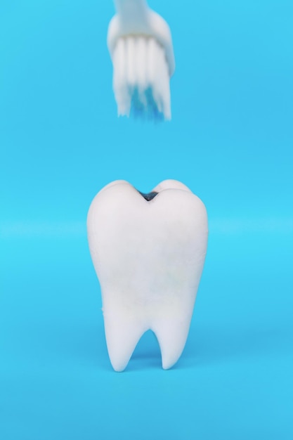 Close-up van een tandenborstel over een gebit tegen een blauwe achtergrond