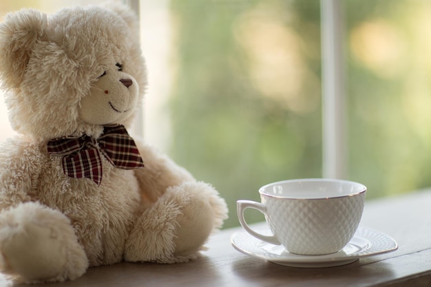 Close-up van een teddybeer en een koffiebeker op tafel