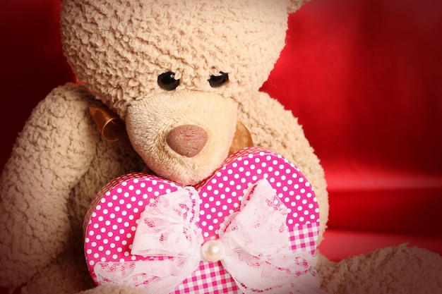 Close-up van een teddybeer met een grote geschenkdoos als hart