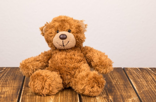 Close-up van een teddybeer op tafel tegen een witte muur