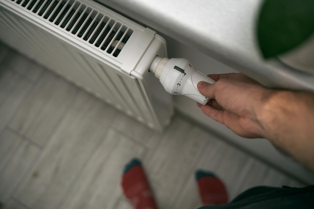 Close-up van een thermostaat op de verwarmingsradiator Verwarmingsregelaar in het moderne witte interieur Temperatuurknop