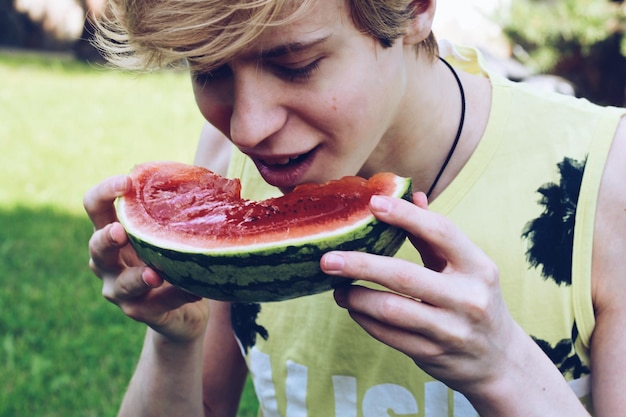 Foto close-up van een tiener die watermeloen eet