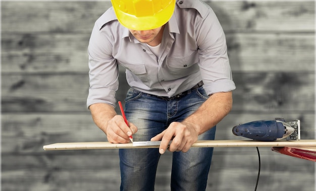 Foto close-up van een timmerman die een houten plank meet