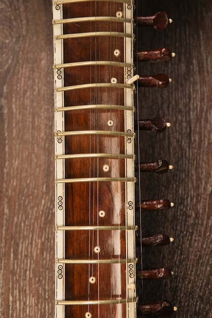 Close-up van een toets Indiase muziekinstrument sitar liggend op een houten vloer - afbeelding