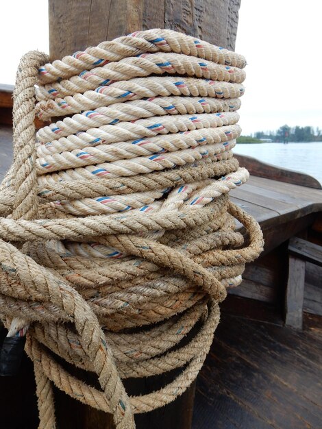 Foto close-up van een touw vastgebonden aan een bollard op het bootdek