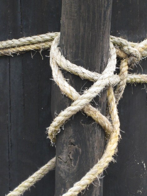 Close-up van een touw vastgebonden aan een houten paal