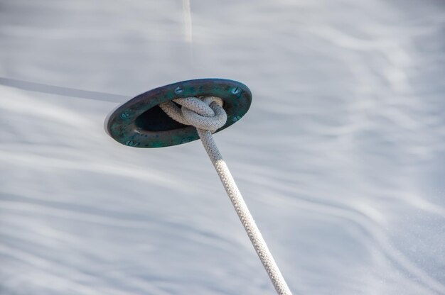 Foto close-up van een touw vastgebonden aan metaal over zee