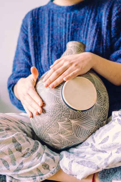 Close-up van een udu-trommel, een Afrikaans percussie-instrument gespeeld door een onherkenbare verticale foto van een vrouw