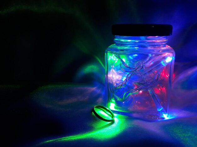 Foto close-up van een verlichte glazen pot op tafel