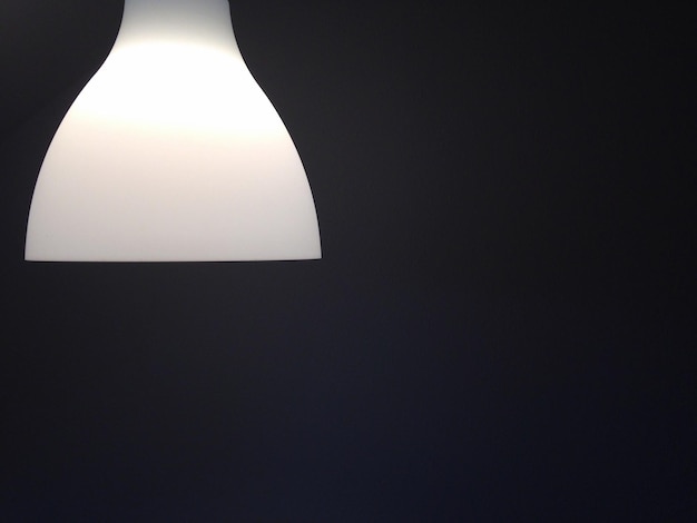 Foto close-up van een verlichte hanglamp in een donkere kamer