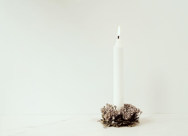 Foto close-up van een verlichte kaars op tafel tegen een witte achtergrond